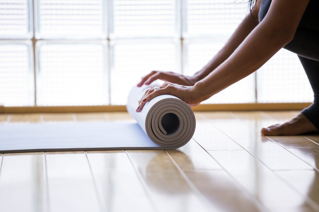 Woman rolling her mat after a yoga class